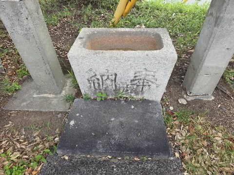 参道脇の石造水盤。正面に「奉納」の二字を刻む。