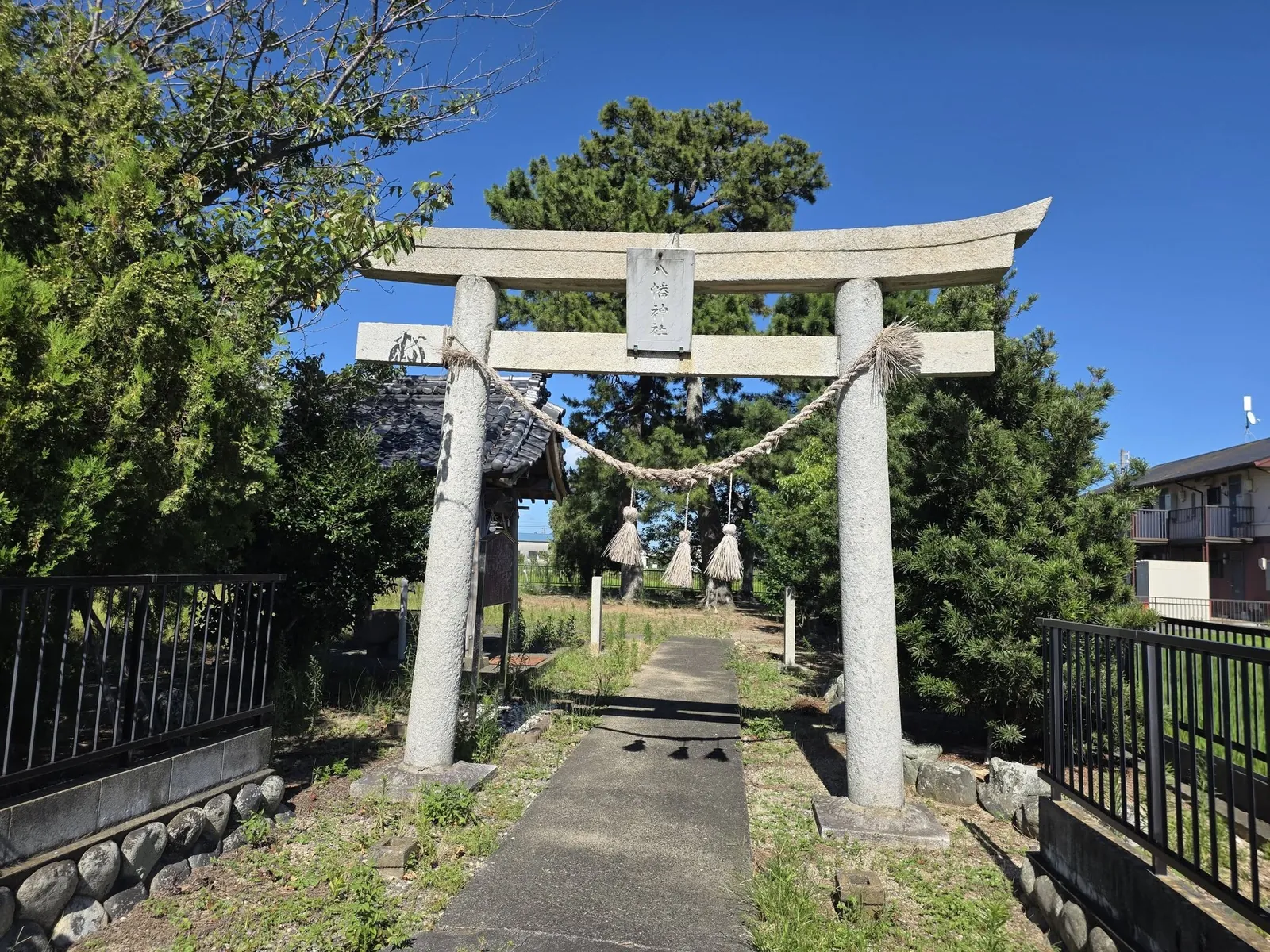 石造鳥居の正面から境内と参道を望む。