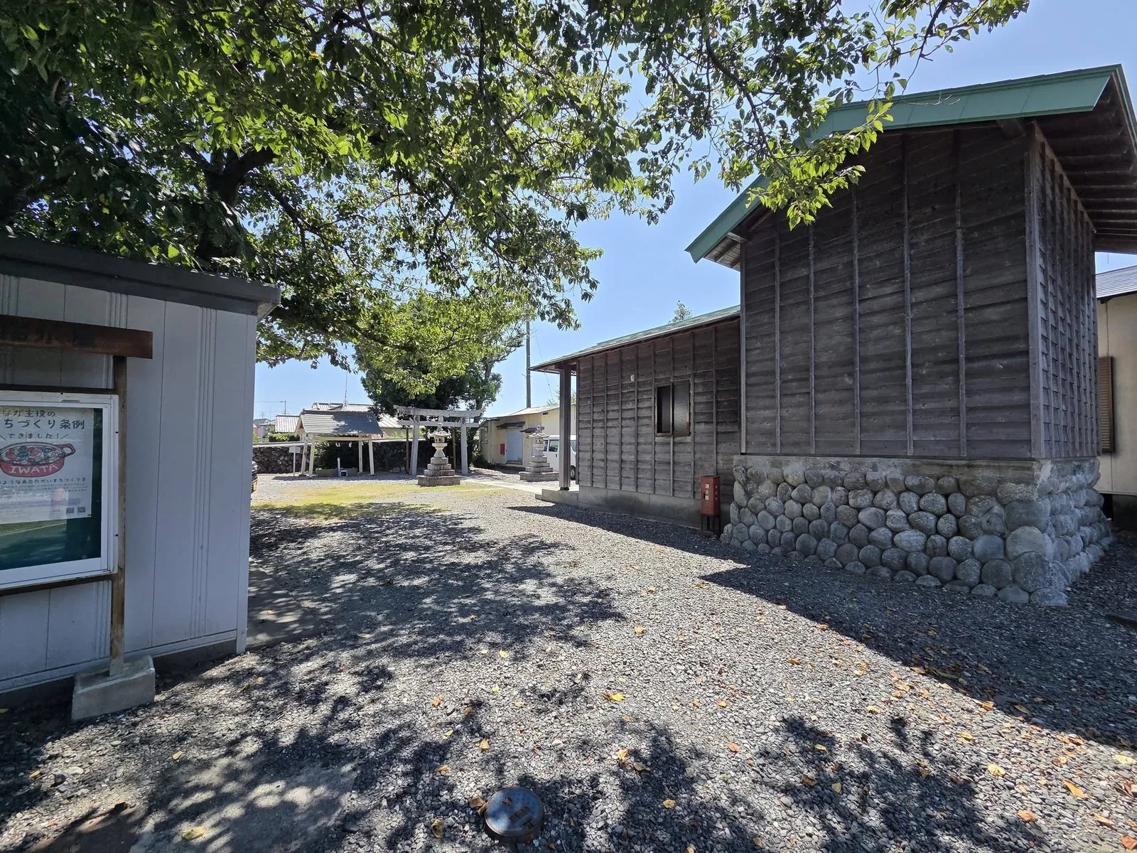 境内の木陰から見た八幡神社の社殿。