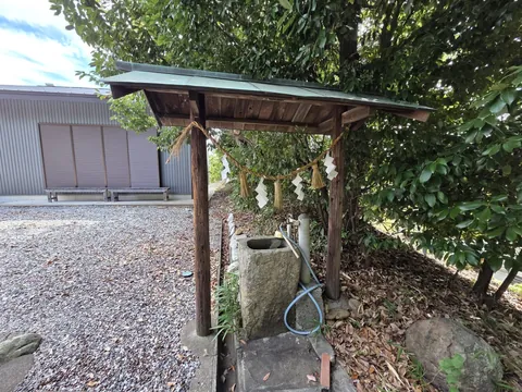 屋根付きの手水舎に置かれた石造の手水鉢。