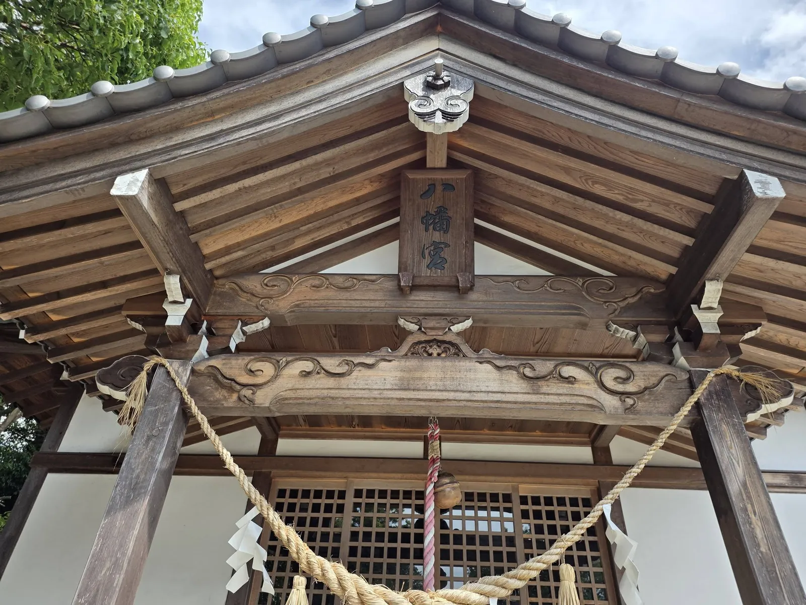 石段の途中から見上げた石造鳥居の正面。注連縄が掛けられている。