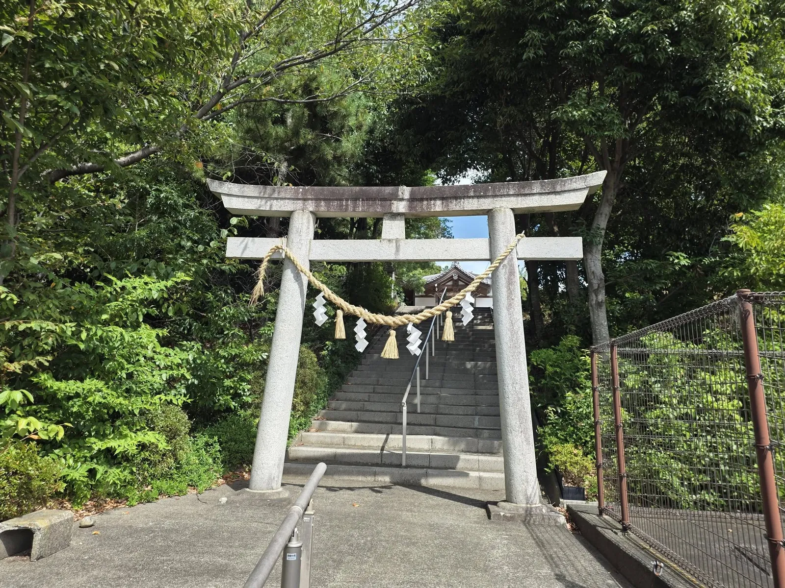 拝殿の正面軒下を見上げたアングル。「八幡宮」の扁額と鈴が下がる注連縄が見える。
