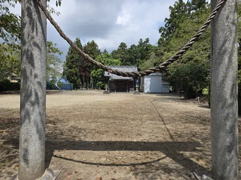 注連縄を掛けた鳥居越しに社殿を望む。