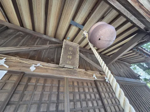 社殿正面に掲げられた「白山神社」の神額と鈴。