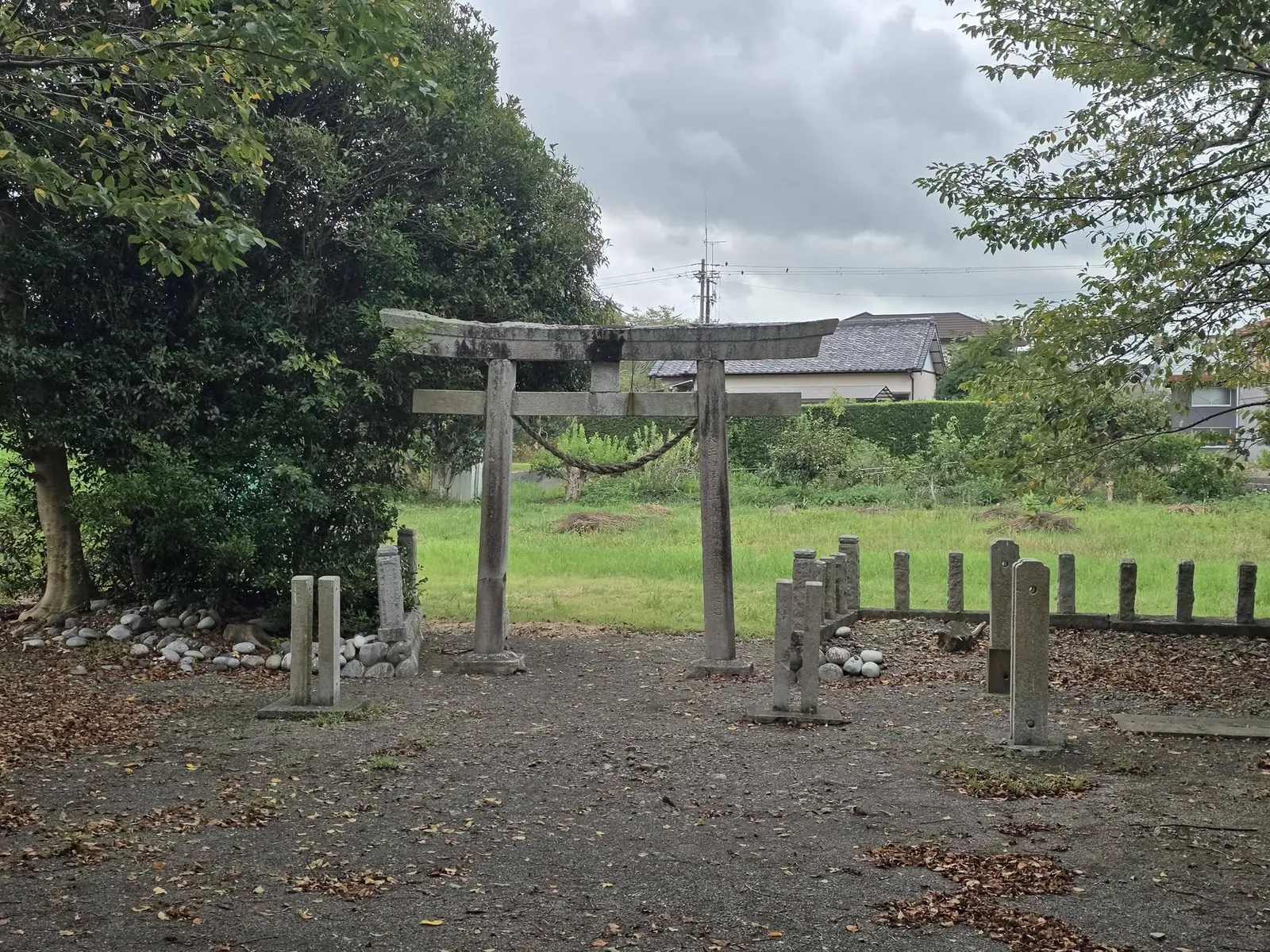 境内側から見る石造鳥居と玉垣。鳥居の先は田園に開ける。