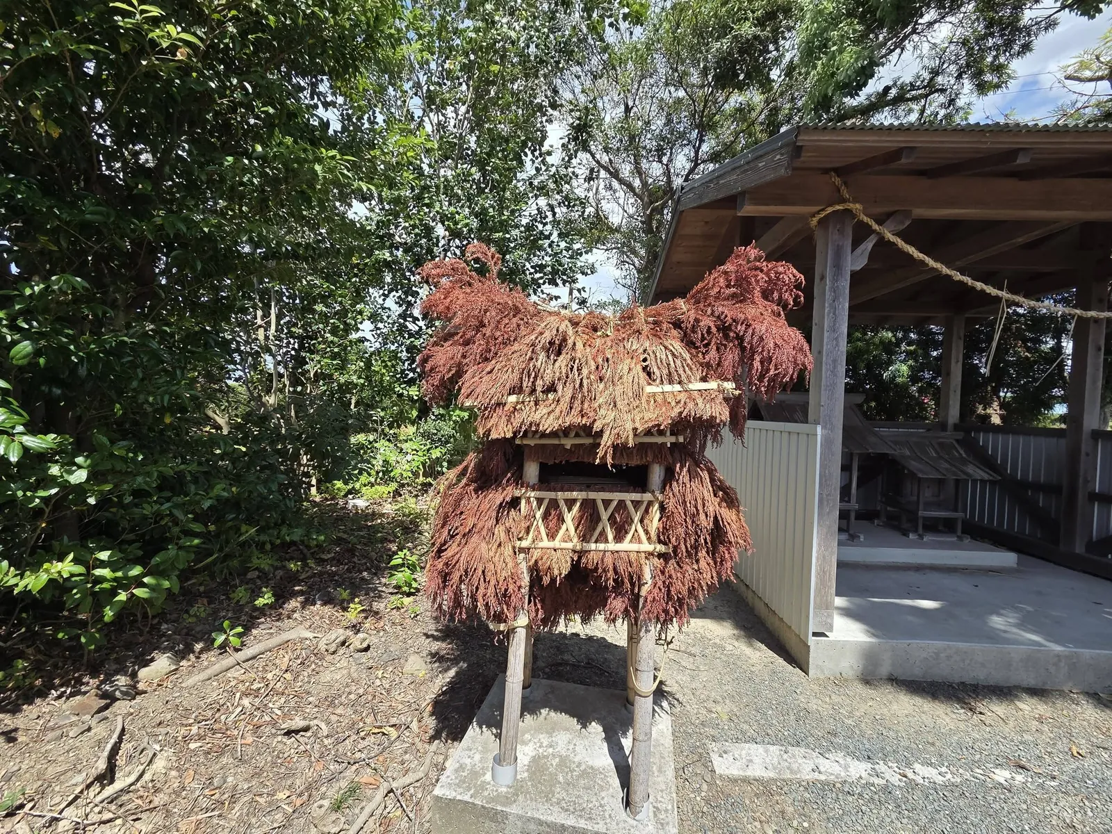 社殿脇に置かれた杉の葉で作られた飾り物を間近から見る。獅子頭のような形に結われている。