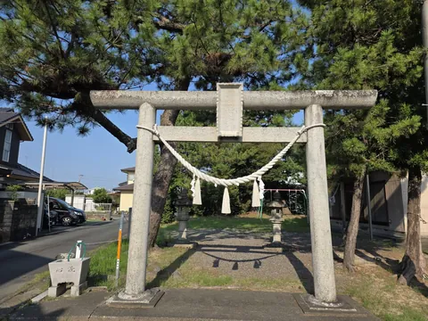 十二社神社：境内入口の石造鳥居。注連縄を張り、額束に石額を掲げる。左手前は手水鉢、参道の先に石灯籠が立つ。