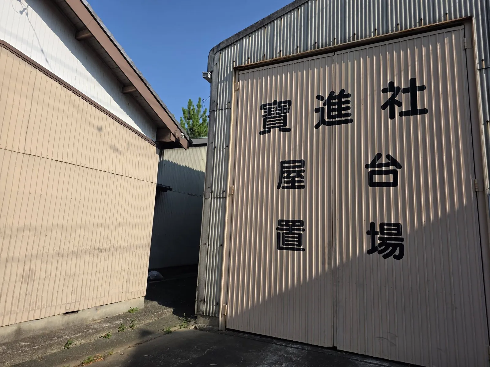 境内に建つ屋台置場。扉に「寶進社 屋台置場」と記す。