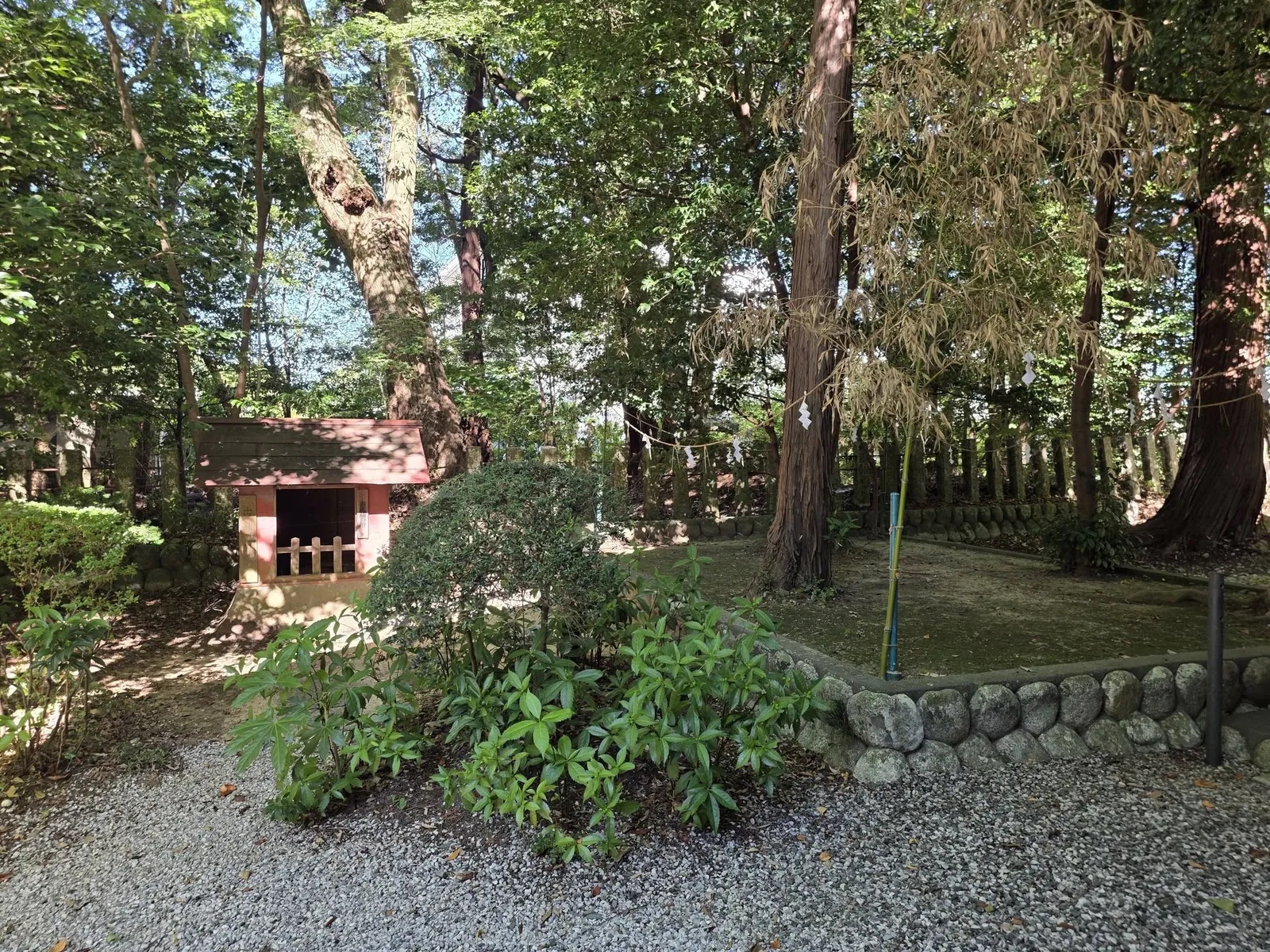 玉垣で囲まれた境内社と周囲の社叢。