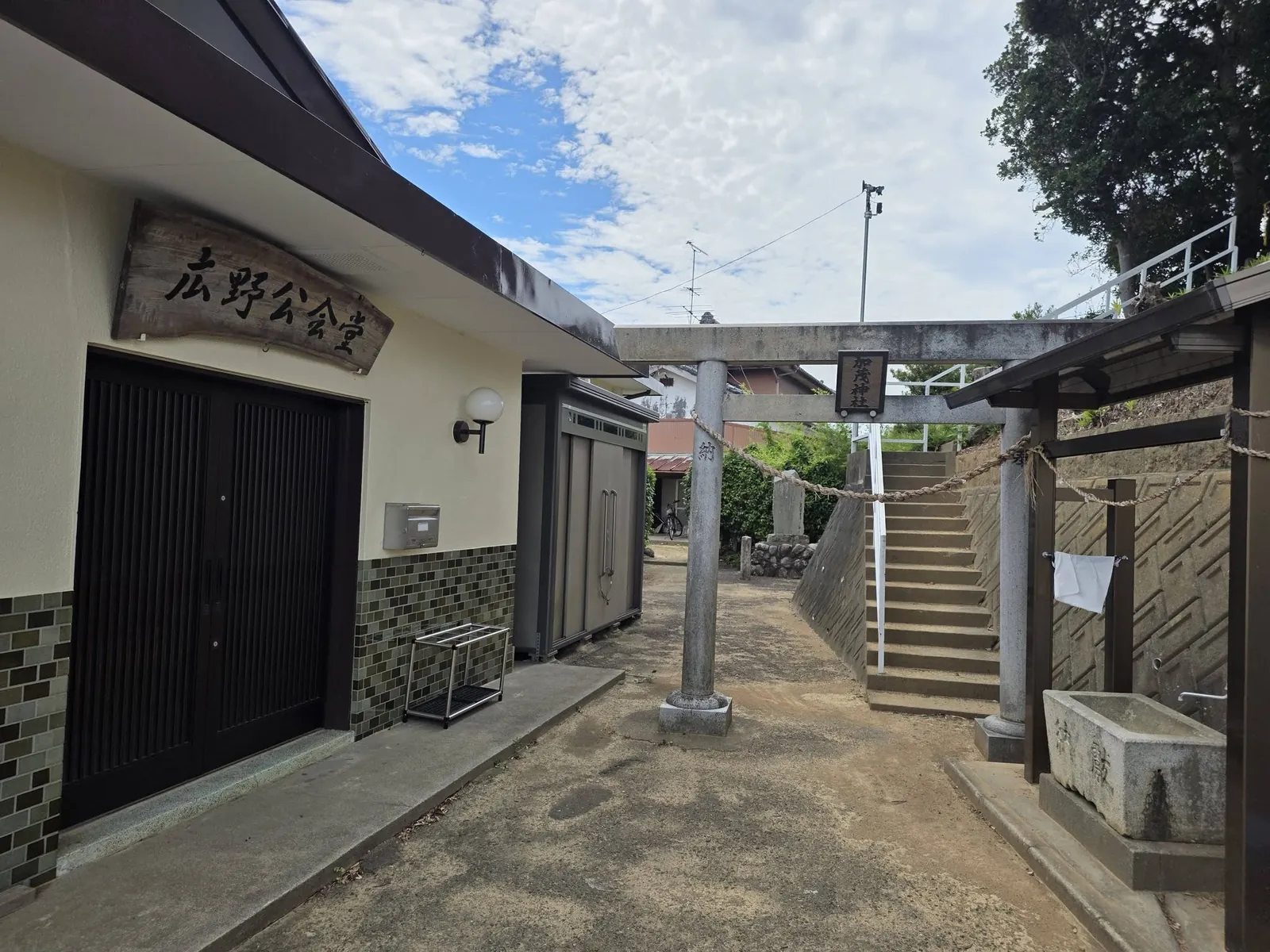 広野公会堂脇から見た鳥居と石段。