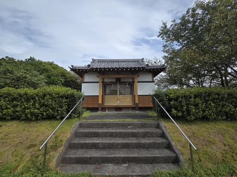 石段正面から見る社殿。瓦葺の入母屋屋根を掛ける。