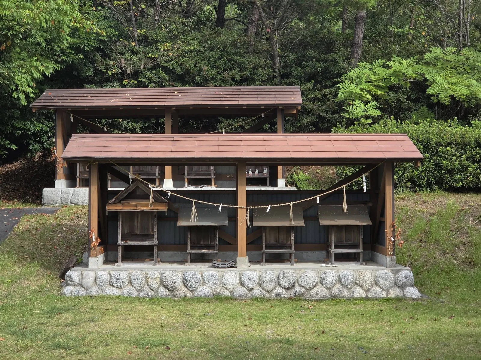 境内に並ぶ小祠群。覆屋の内側に複数の祠を安置する。