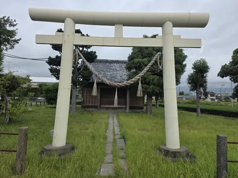 境内入口の明神鳥居。石敷きの参道の先に社殿が立つ。