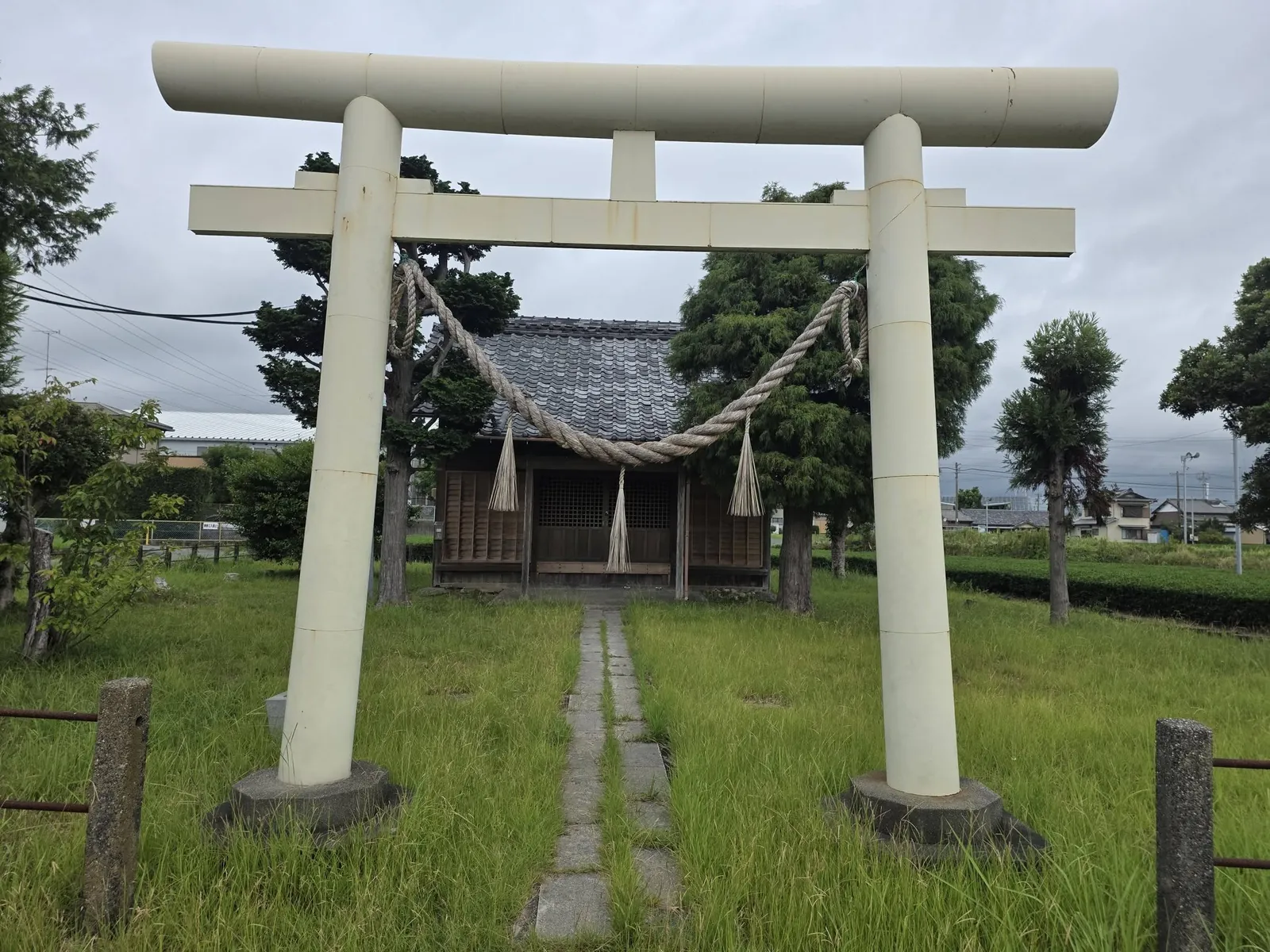 境内入口の明神鳥居。石敷きの参道の先に社殿が立つ。