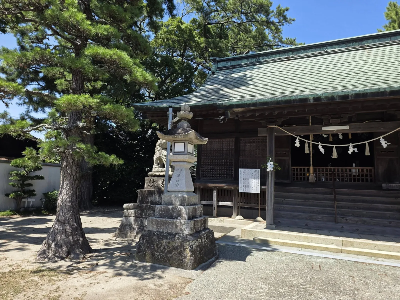 松の木と石灯籠を前景にした貴船神社の社殿。