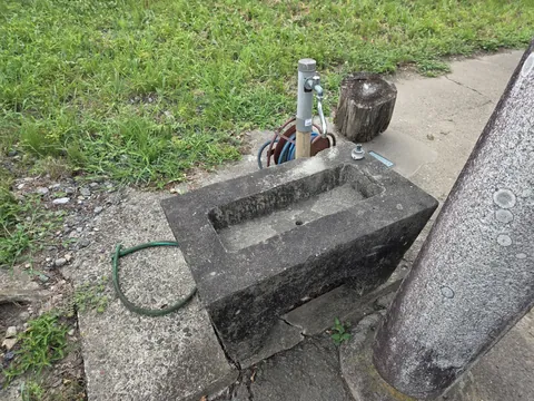 鳥居脇に置かれた石造の手水鉢。