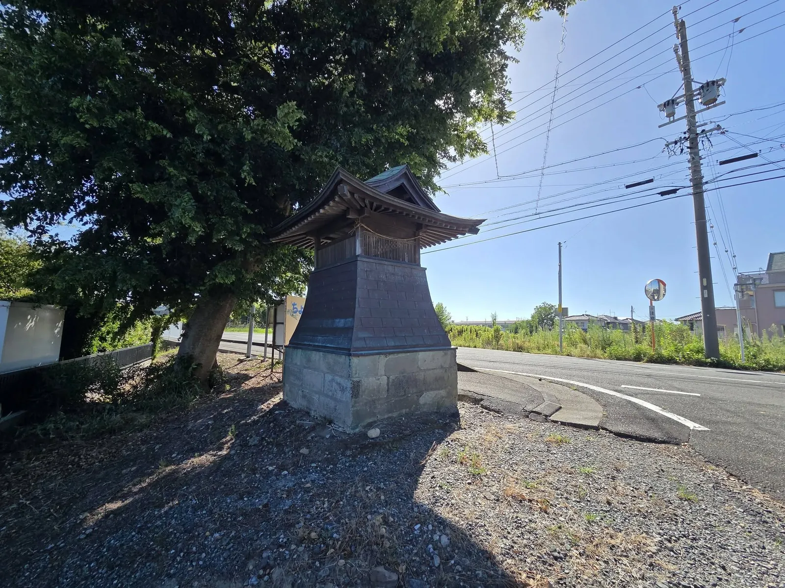 道路脇に建つ木造の小社。