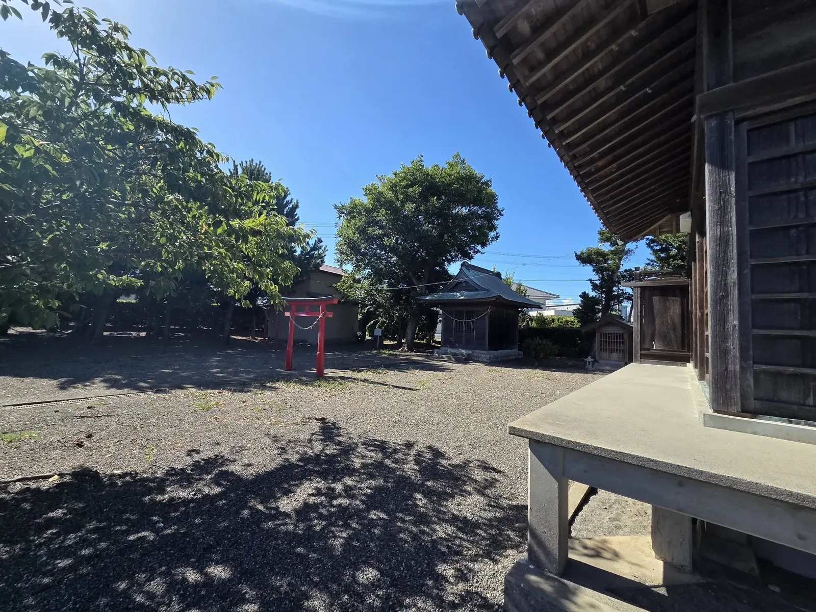 社殿側から朱塗りの鳥居と境内社を望む。