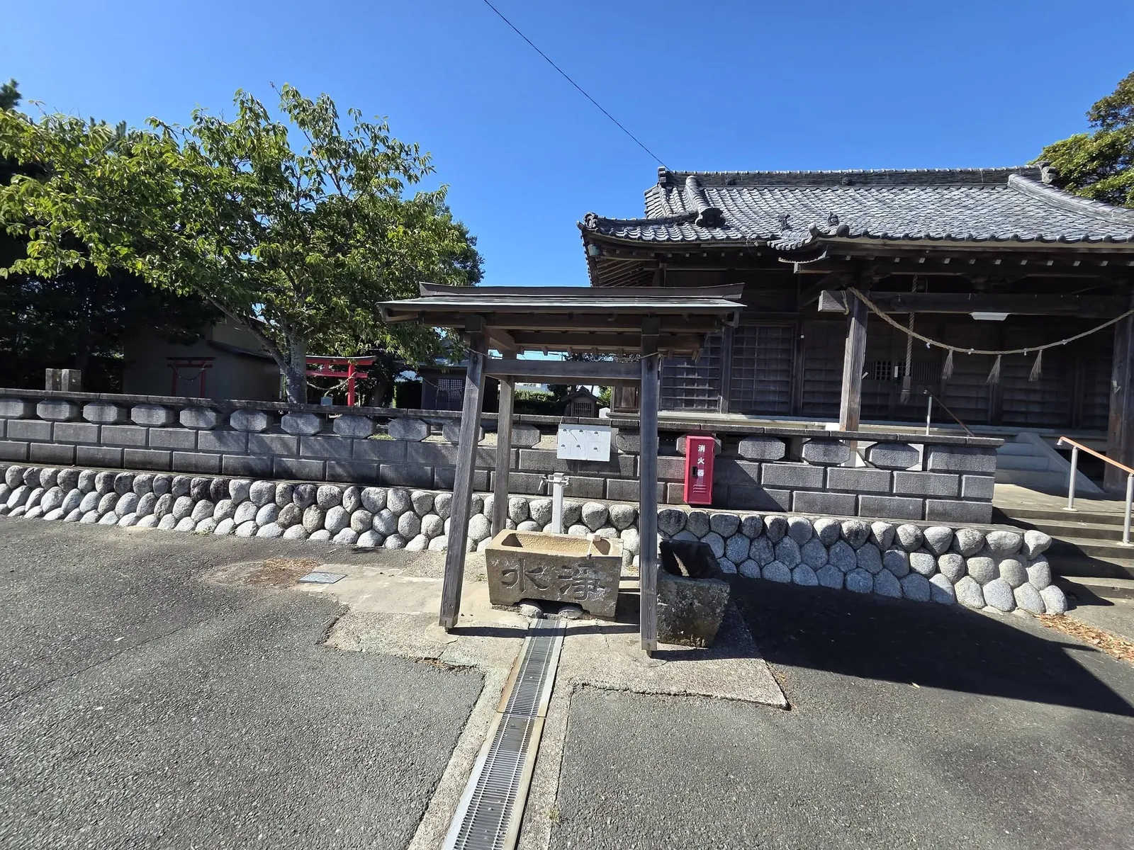 手水鉢とその奥に建つ社殿。