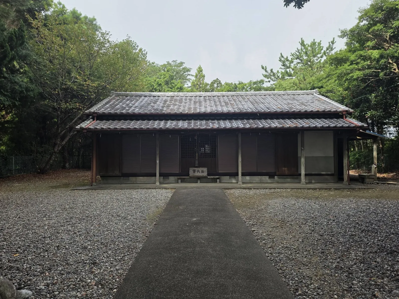 参道正面から見る社殿。広い砂利敷きの境内奥に立つ。