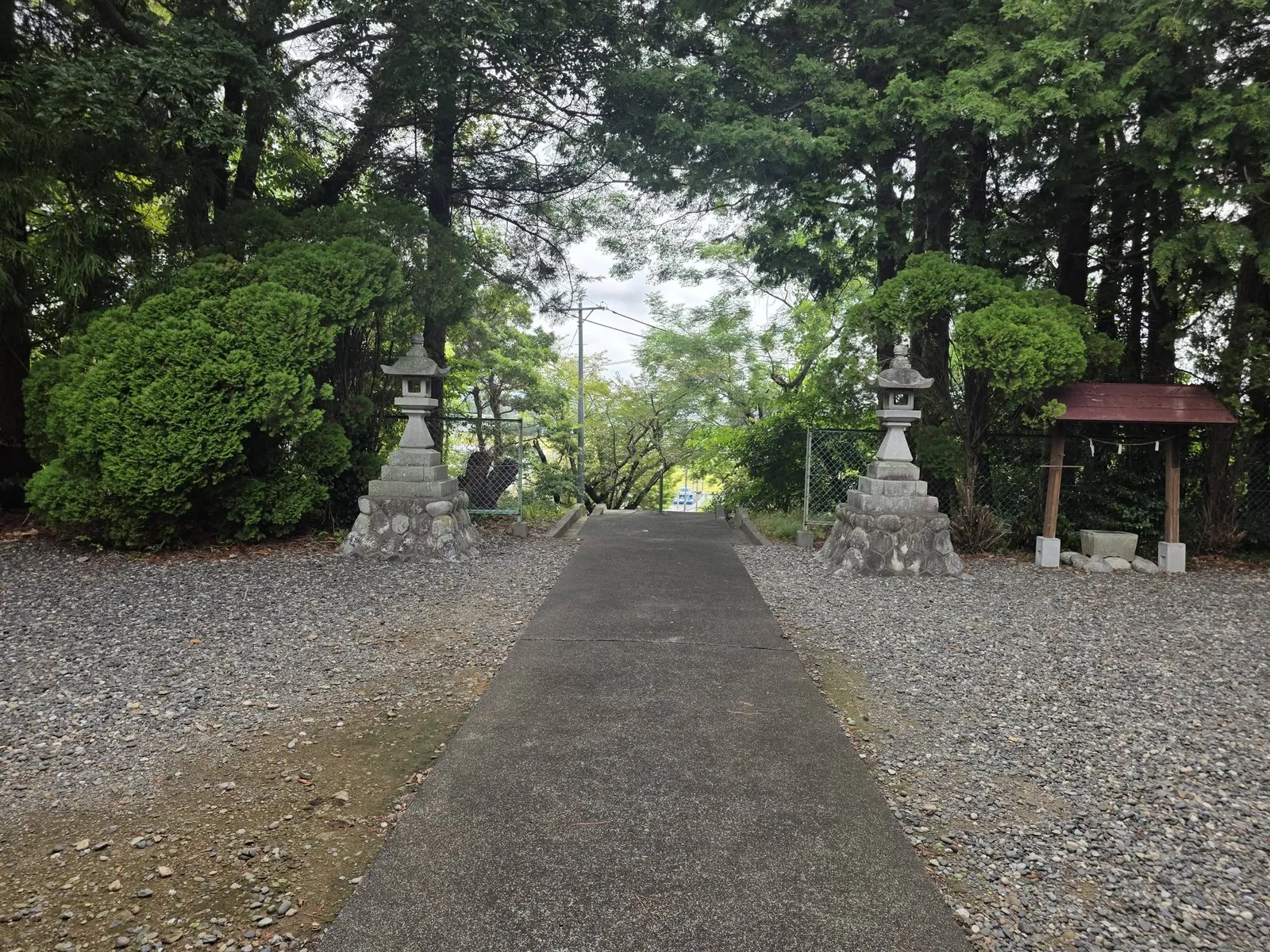社殿側から鳥居方向を見る参道。石灯籠と手水舎が左右に立つ。