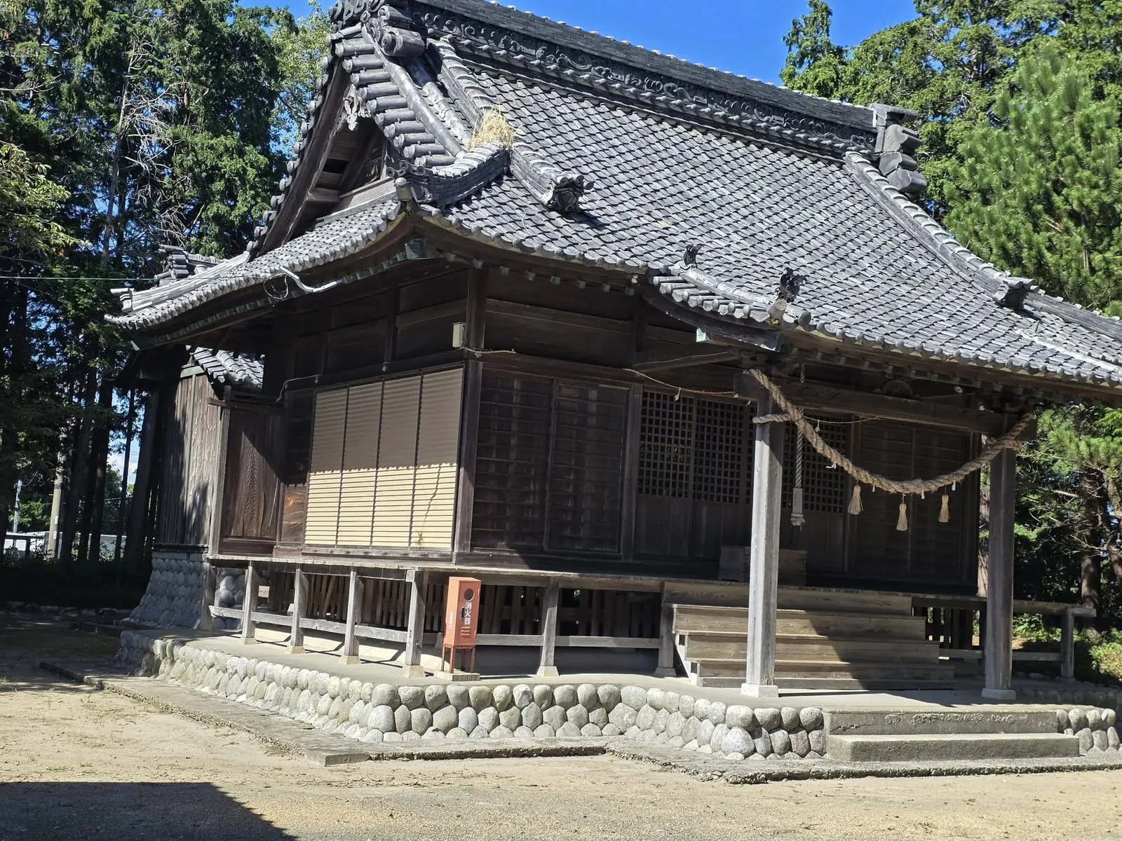 瓦葺きの屋根と注連縄を備えた松尾神社の社殿。