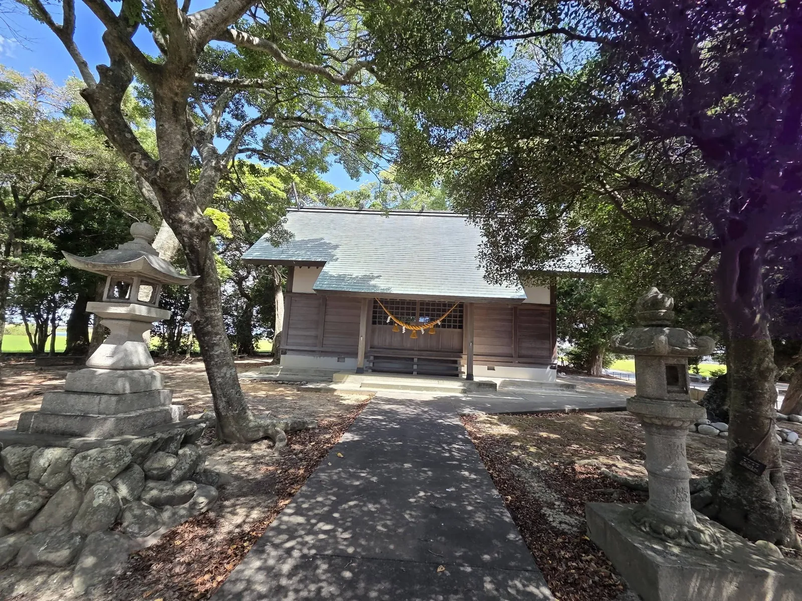 石造鳥居と石灯籠越しに望む藻山神社の社殿。