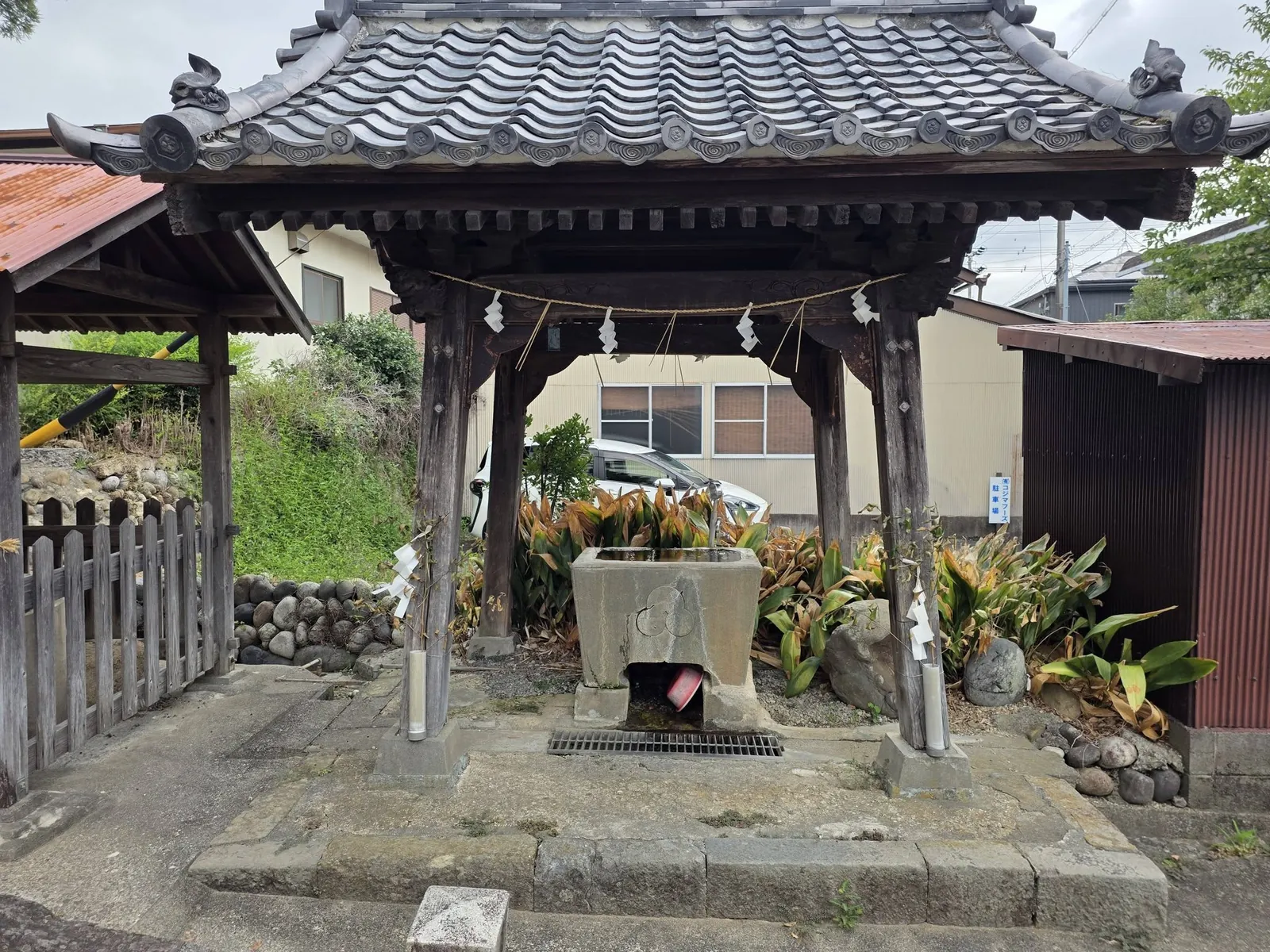 境内入口脇の手水舎。瓦葺きの屋根の下に水盤を据える。