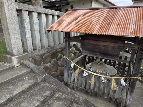 覆屋の中に祀られた境内の石祠。