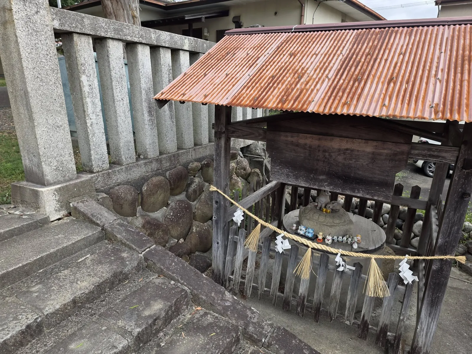 覆屋の中に祀られた境内の石祠。