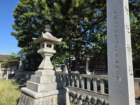 境内入口に立つ石灯籠。竿に奉献の銘を刻む。
