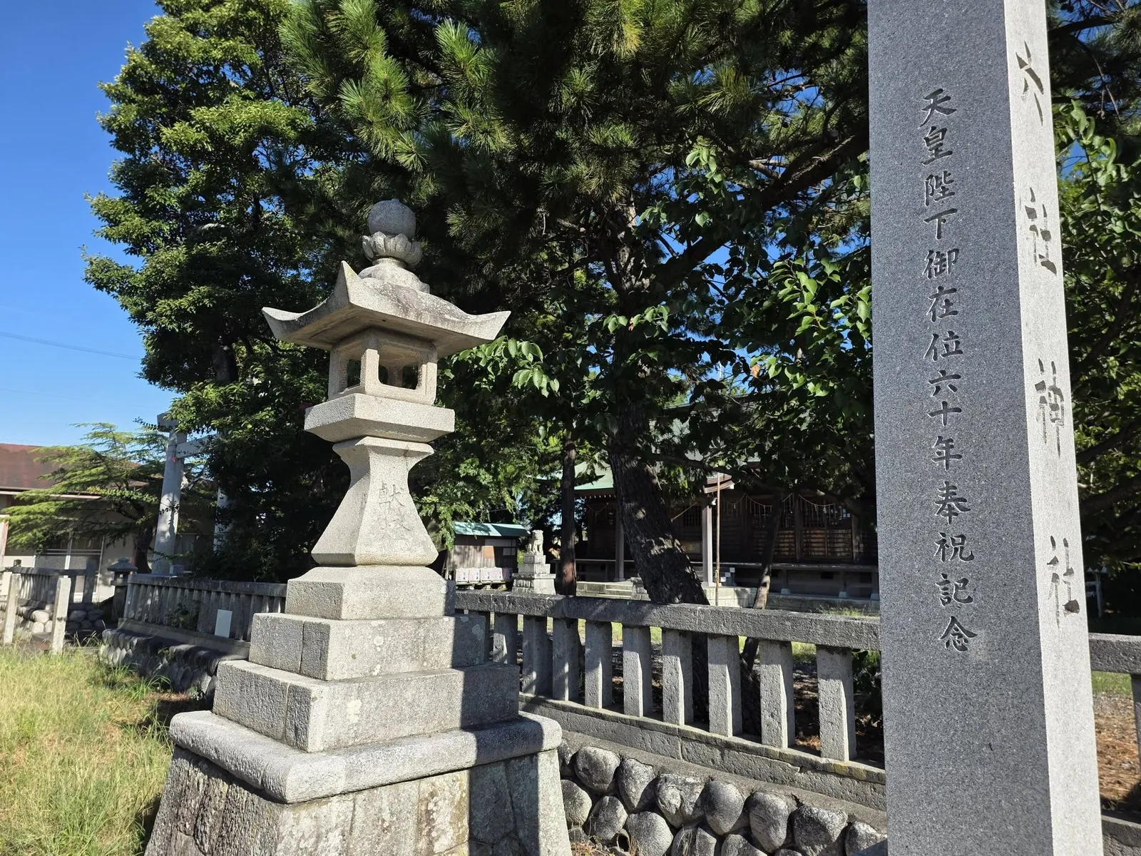 境内入口に立つ石灯籠。竿に奉献の銘を刻む。