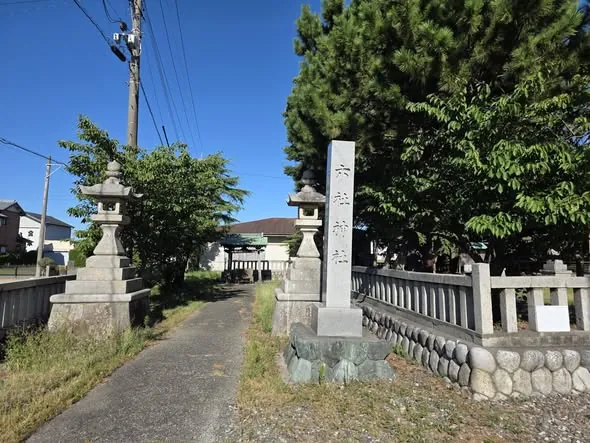 参道入口の社号標と石灯籠。社号標には「六社神社」と刻む。