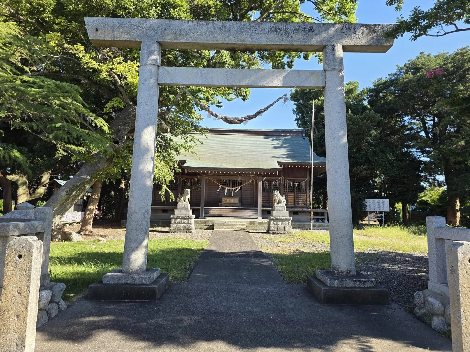 石造鳥居を正面から見る。鳥居の先に参道と拝殿が続く。