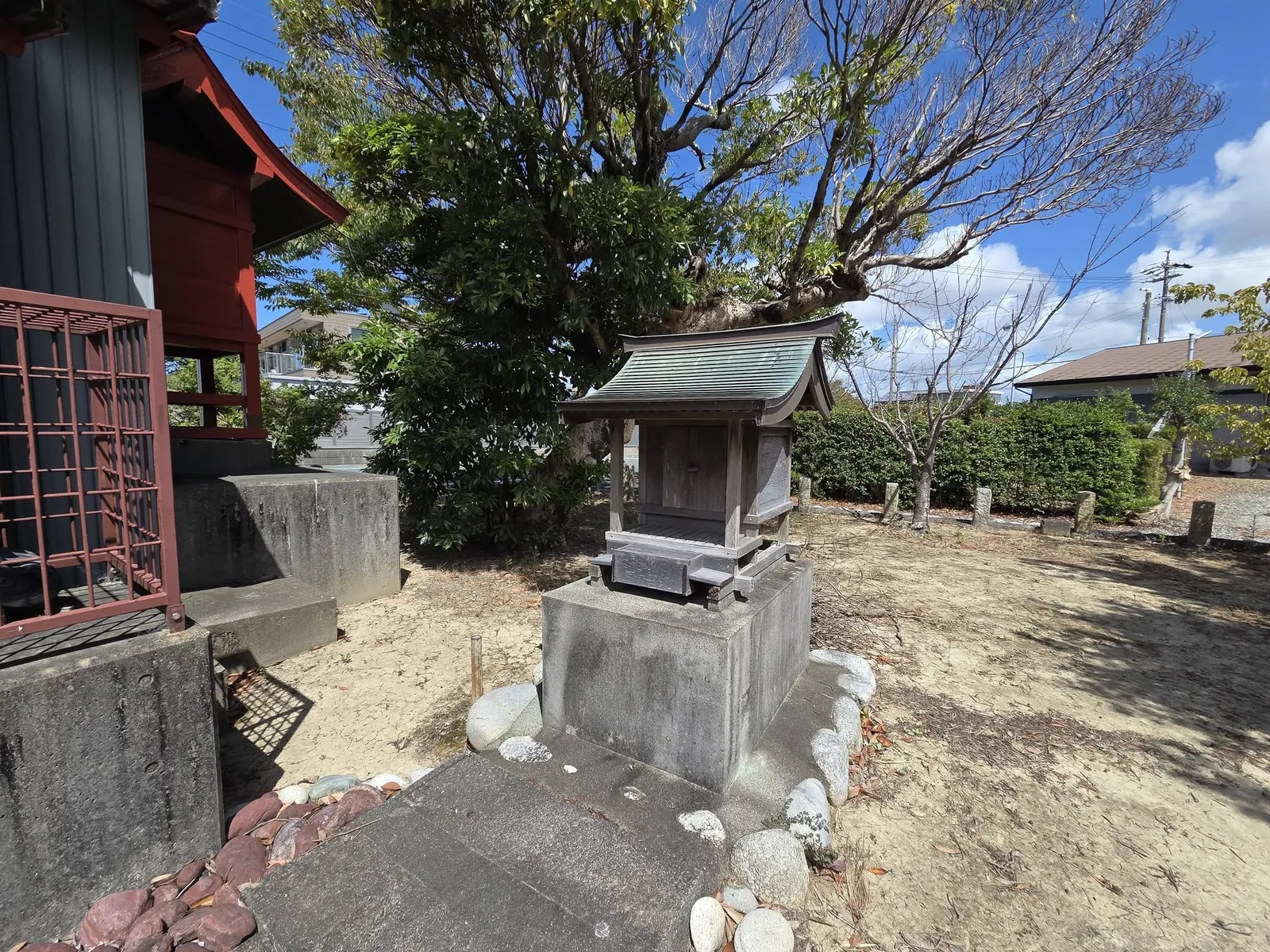 境内の小祠。背後に社叢の木々が広がる。