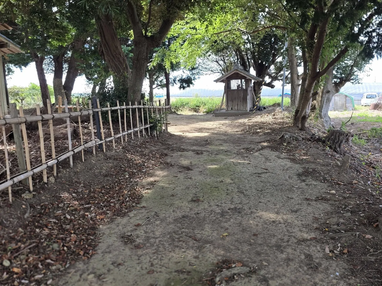 竹垣沿いの参道の奥に、木造の境内社(祠)が見える。
