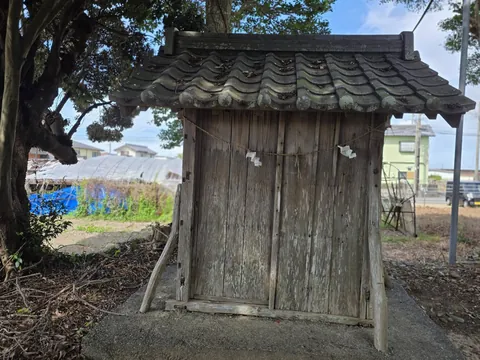境内社(祠)の正面。瓦葺きの屋根と木製の扉、しめ縄と紙垂が見える。