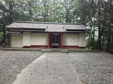 参道正面から見る社殿。白壁と朱塗りの柱を備える。