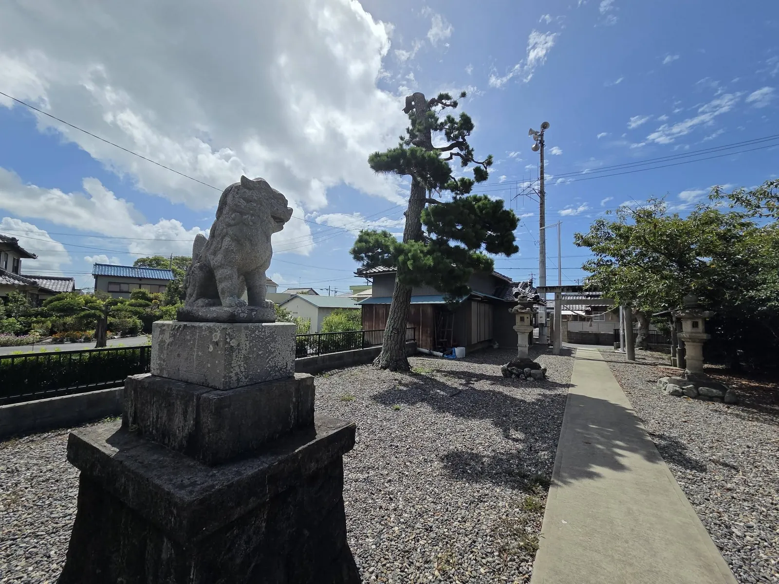 参道脇の狛犬。奥に石造鳥居と石灯籠が並ぶ。