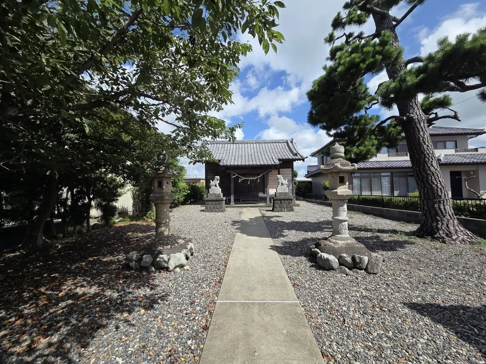 石灯籠の間を通る参道の先に六所神社の社殿を望む。