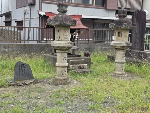 境内の石灯籠と「隆納社」の石碑。