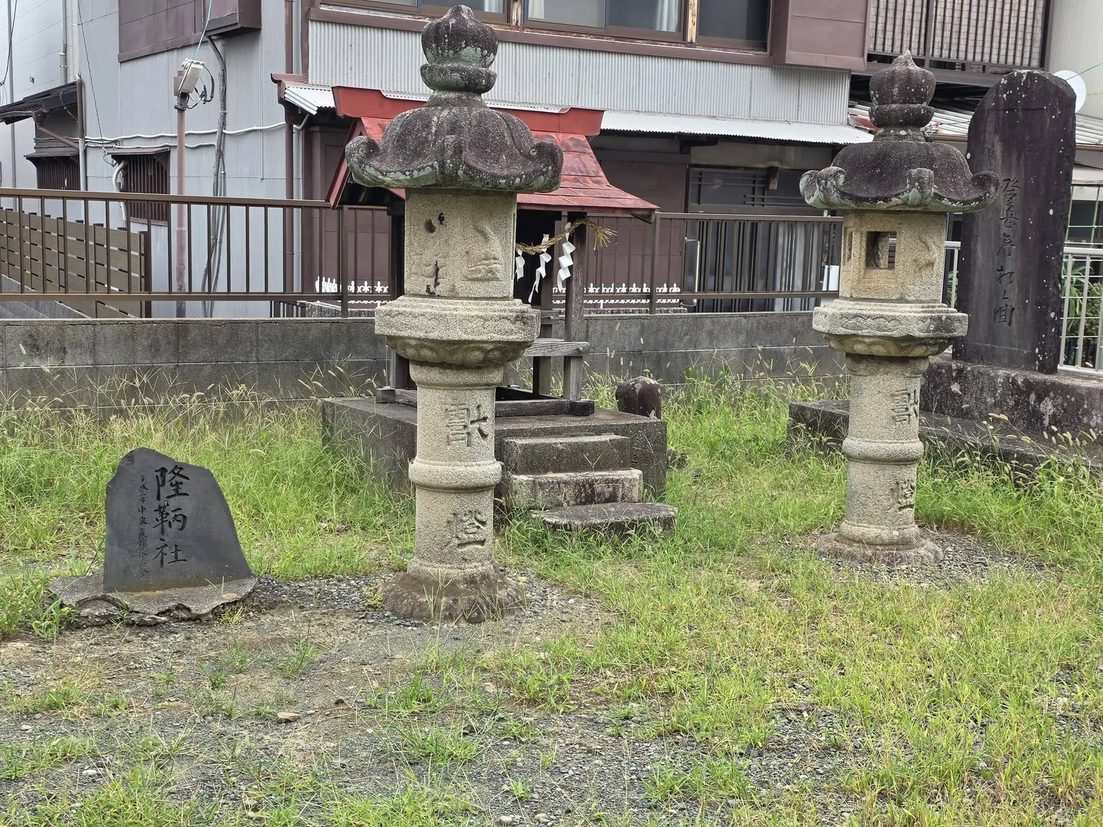 境内の石灯籠と「隆納社」の石碑。