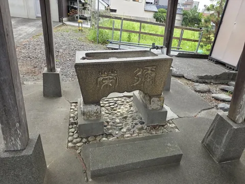 手水舎の石造水盤。正面に「奉納」と刻む。