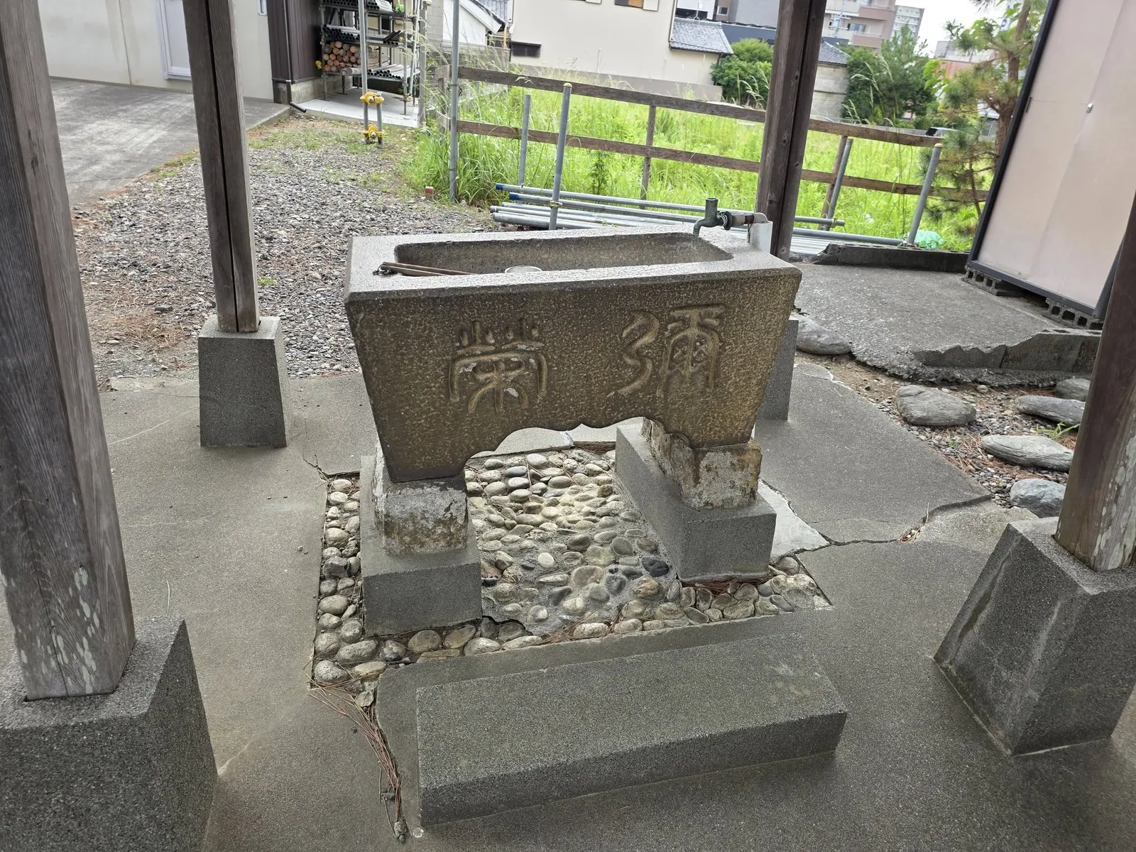 手水舎の石造水盤。正面に「奉納」と刻む。
