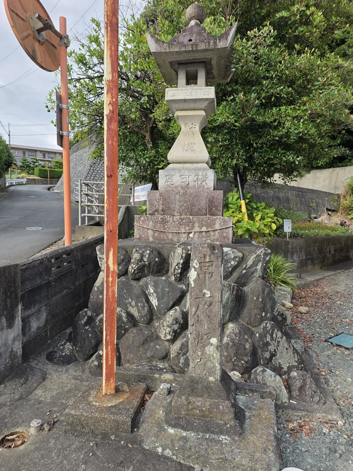 境内入口脇の石灯籠。石積みの上に立つ。