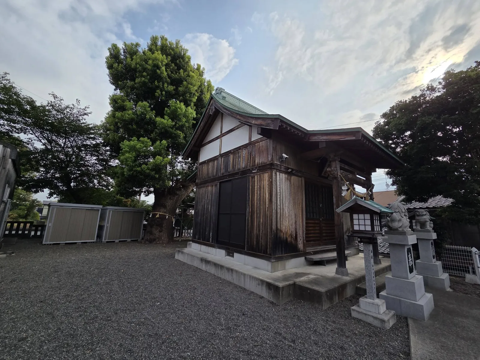 社殿を斜め後方から見る。木造の外壁と屋根の構成が分かる。