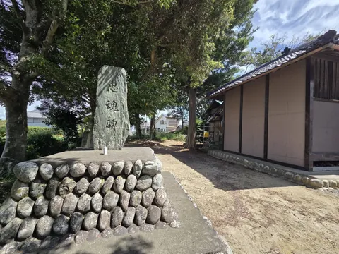 境内に立つ「忠魂碑」と刻まれた石碑。奥に瓦屋根の建物が見える。