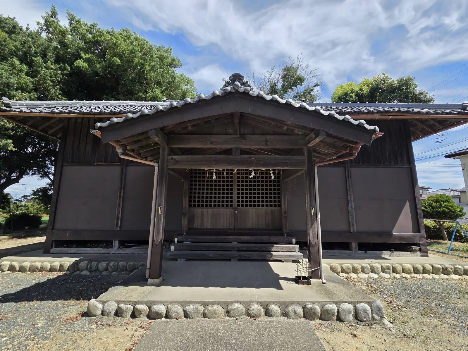 拝殿正面。中央の格子戸にしめ縄と紙垂が掛けられ、正面に階段が続く。