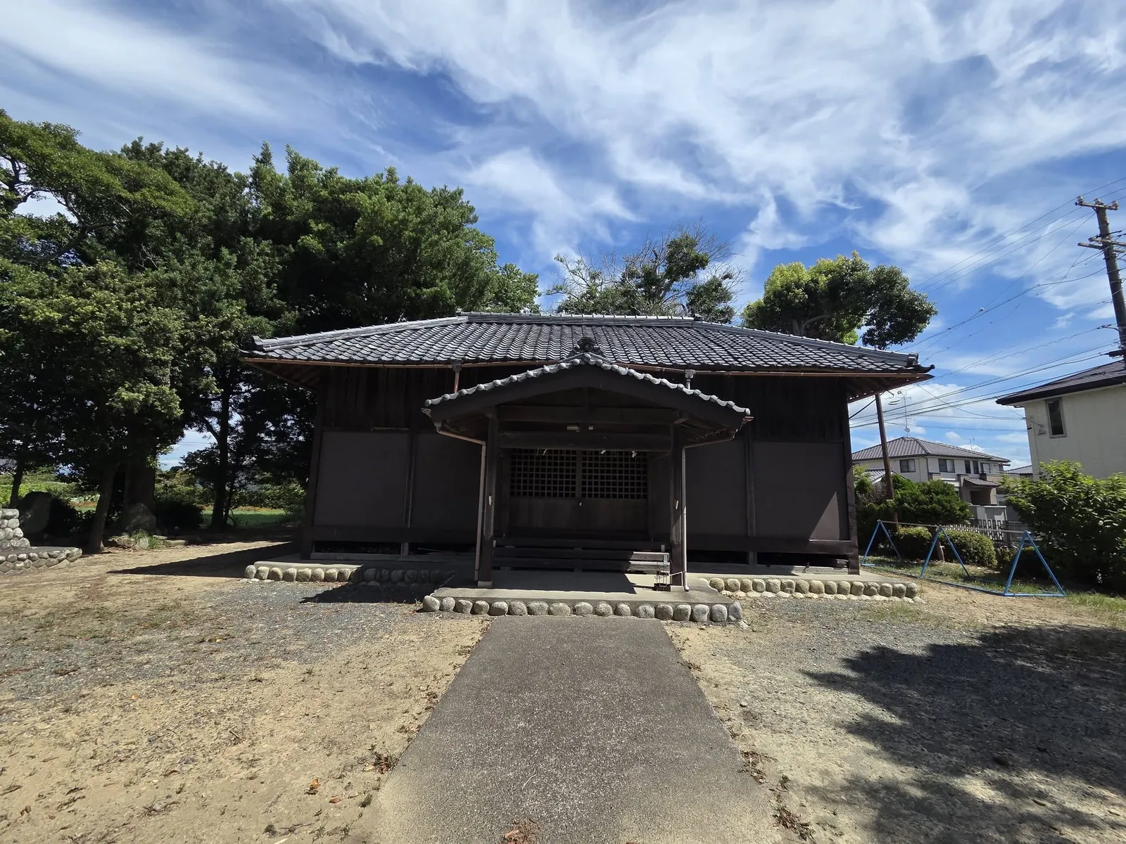 参道から見た拝殿全景。瓦屋根と社殿全体が空を背景に写る。