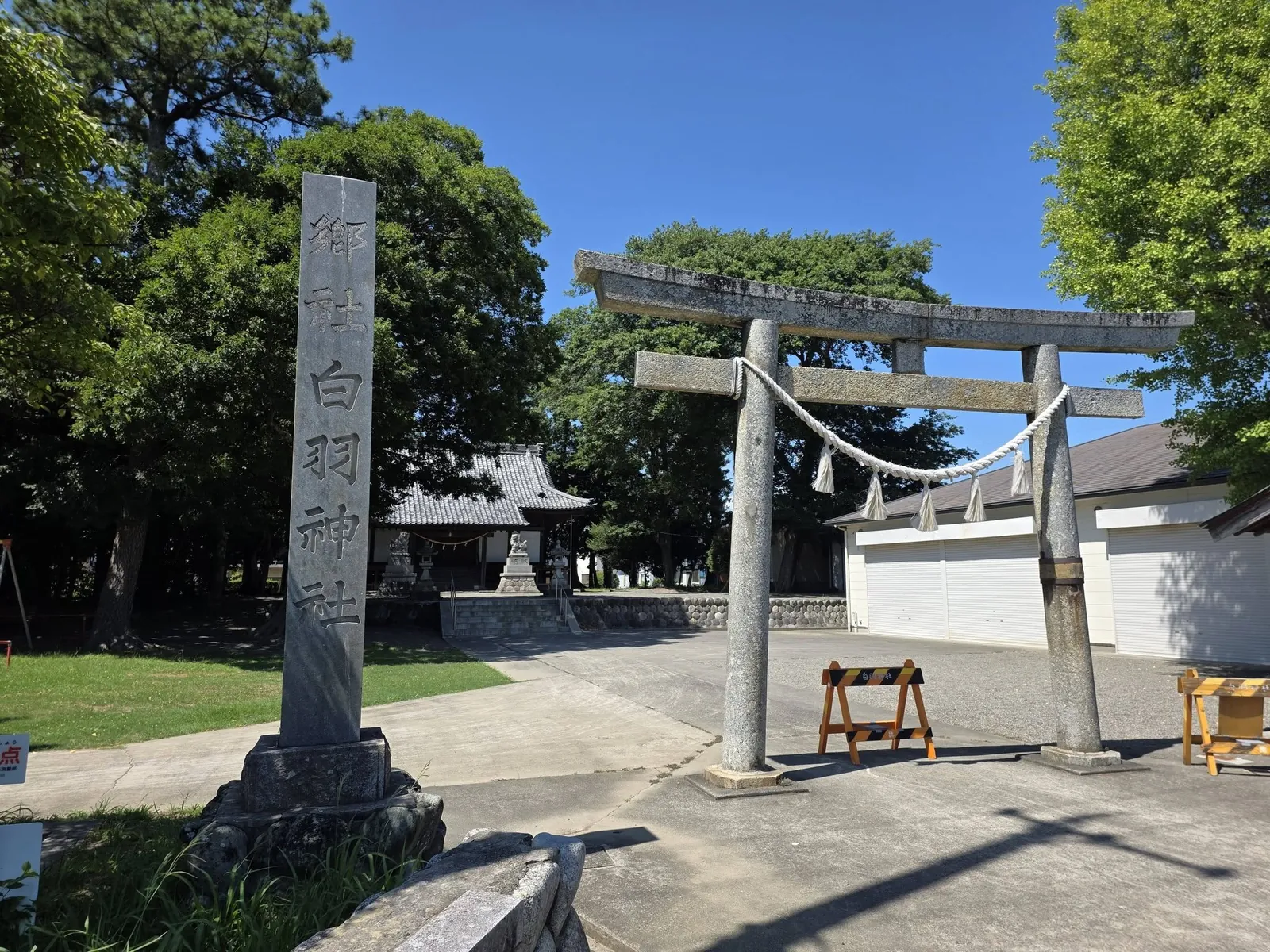 「郷社 白羽神社」と刻まれた社号標と石造鳥居。